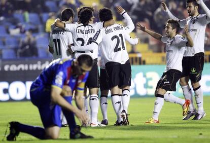 Los jugadores del Valencia celebran el primer gol mientras Ballesteros se ata las botas.