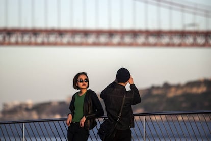 Turistas a orillas del Tajo cerca del puente del 25 de Abril, de 2.277 metros de longitud, que cruza el estuario del gran río.