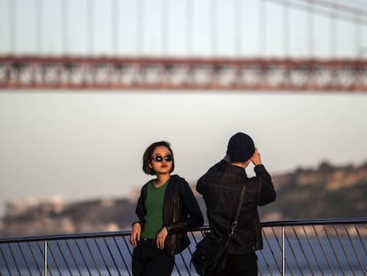 Turistas a orillas del Tajo cerca del puente del 25 de Abril, de 2.277 metros de longitud, que cruza el estuario del gran río.