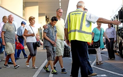 Las autoridades del aeropuerto de Schiphol conducen a los familiares de los pasajeros del vuelo accidentado de Malaysia Airlines a una zona privada en el aeropuerto. 