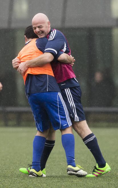 El presidente de la FIFA se abraza con otro de los participantes en el encuentro.