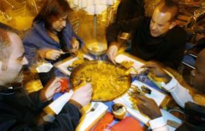 Unos turistas degustan una paella en Valencia. EFE/Archivo