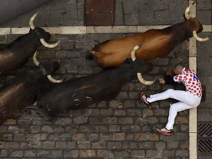 Un mozo en el suelo al paso de los toros.
