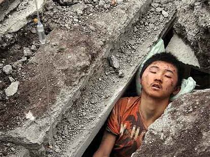 Un joven espera a ser rescatado de entre las ruinas de un edificio en Beichuan