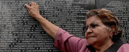 Guadalupe Mejía señala el nombre de su esposo asesinado, en una lista de víctimas de la guerra civil.