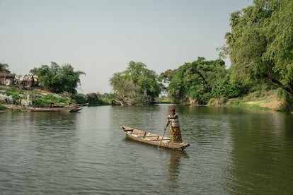 The river level near the village of Igbedor usually drops in January and February. This phenomenon causes sandy islets to resurface. Entire families settle on these islets for about two months, catching and drying fish to sell in local markets. In the photo, a woman paddles in the stretch of the river that separates the village from the agricultural fields. 