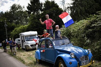 Espectadores en un Citroën 2CV, ondean una bandera francesa durante la quinta etapa de la 105ª edición del Tour de Francia, entre Lorient y Quimper, oeste de Francia, el 11 de julio de 2018.
