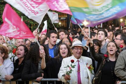 Militantes socialistas esperan con banderas y rosas a François Hollande ante la sede del partido en París.