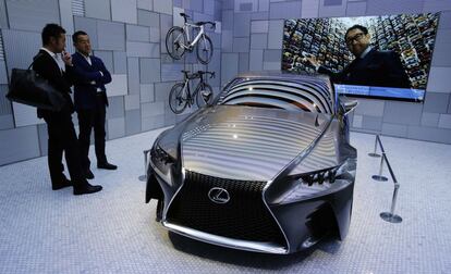 Dos visitantes observan en el nuevo espacio de lujo de Tokio el prototipo Lexus LF-CC, desvelado en el Salón de París de 2012.