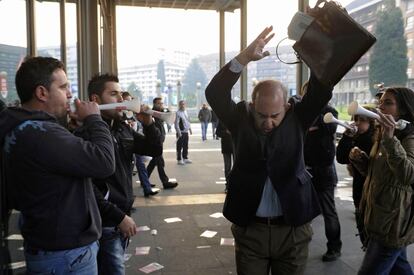 Un grupo de piqueteros increpan a un trabajador público que llega a su lugar de trabajo durante la huelga general en Oviedo.