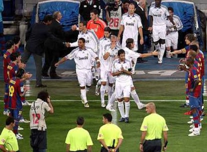 Los jugadores del Barça hacen pasillo a los del Madrid al inicio del partido.