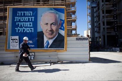 Un hombre camina frente a un cartel electoral de Netanyahu en Tel Aviv.
