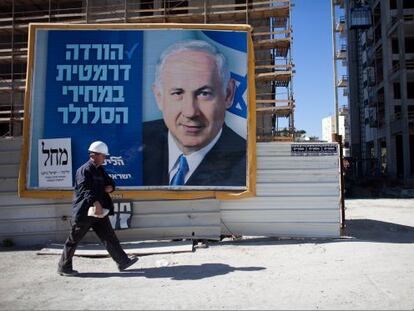 Un hombre camina frente a un cartel electoral de Netanyahu en Tel Aviv.