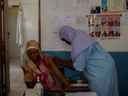 Una doctora del centro de salud de Uroa, en Zanzíbar, vacuna a una vecina.