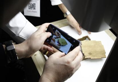Un congresista de Madrid Fusión fotografía un platro de Andoni Luis Aduriz: pañuelo de mochi (pasta de arroz glutinoso) con flores, servido en una caja.