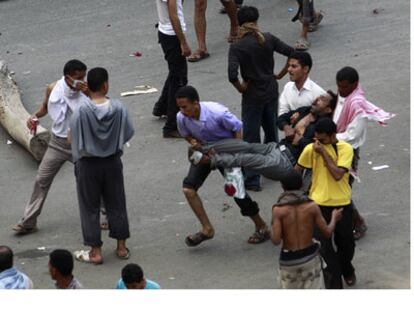 Unos manifestantes transportan un hombre herido durante una protesta en Taiz.