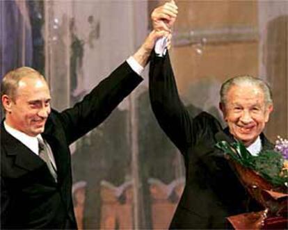 El presidente ruso Vladímir Putin levanta el brazo de Juan Antonio Samaranch ayer en Moscú.