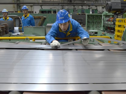 En la imagen, operarios cortan láminas de titanio en una factoría de Daming International Holdings Co. en Wuxi, China.