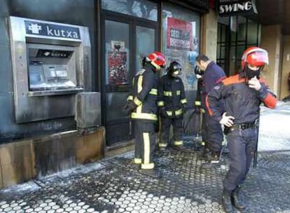 Agentes de la Ertzaintza y bomberos examinan los daños causados por el ataque a un cajero en San Sebastián<i>.</i>