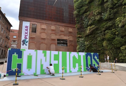 Jorge Muñoz y Pablo Purón, integrantes de Boa Mistura, pintan el mural con la palabra conflictos en CaixaForum (Madrid).
