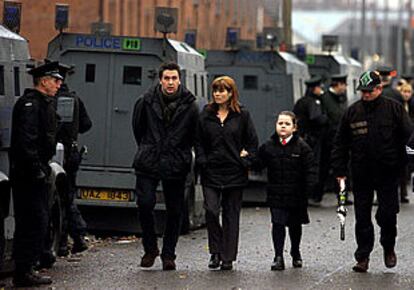 Los niños acudieron a las aulas -como muestra la fotografía-con sus padres y una fuerte protección policial después de dos noches de violencia extrema