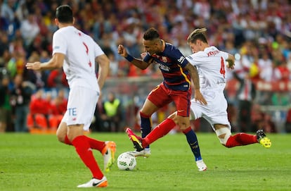 El jugador del Sevilla, Krychowiak, intenta quitar el balón a Neymar.