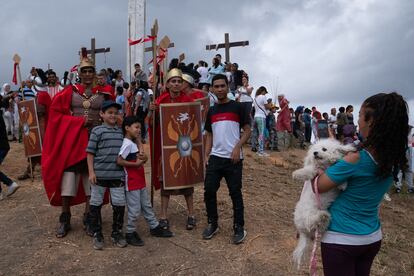 Dos actores se fotografían con creyentes y espectadores durante la interpretación de la Pasión de Cristo, en Petare (Venezuela).