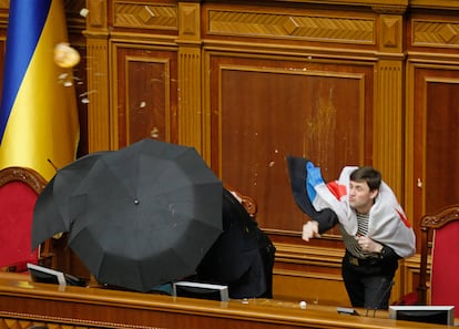 Un diputado del partido pro presidencial, vestido de marinero y cubierto con la bandera de la Armada soviética, lanza huevos contra el presidente de la Cámara  Volodymr Lytvyn, que se cubre debajo de varios paraguas.