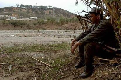 Un agente marroquí vigila la valla de la frontera con Ceuta donde se produjo la avalancha de inmigrantes.