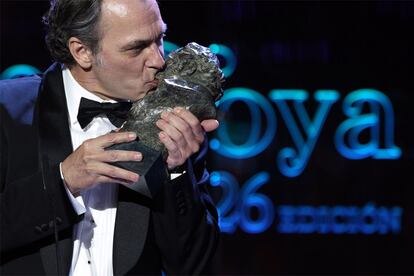 José Coronado besa su Goya a mejor actor principal por su papel en 'No habrá paz para los malvados'.