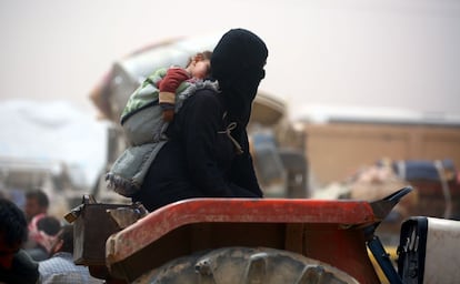 A displaced Syrian woman, who fled the countryside surrounding the Islamic State (IS) group stronghold of Raqa, arrives at a temporary camp in the village of Ain Issa on April 28, 2017. / AFP PHOTO / DELIL SOULEIMAN