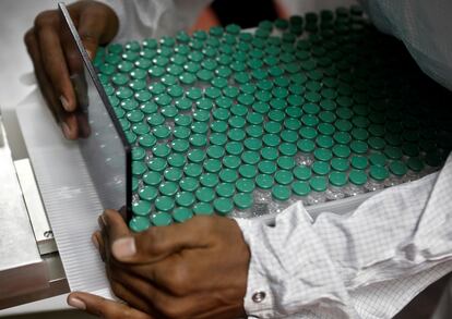Un empleado del laboratorio Serum Institute de la India, extrae viales de la vacuna de AstraZeneca contra la covid-19.