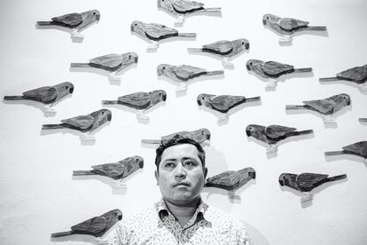 El artista Edinson Quiñones frente a su obra 'Loras y Perikos', expuesta en la Galería 980 de Bogotá.