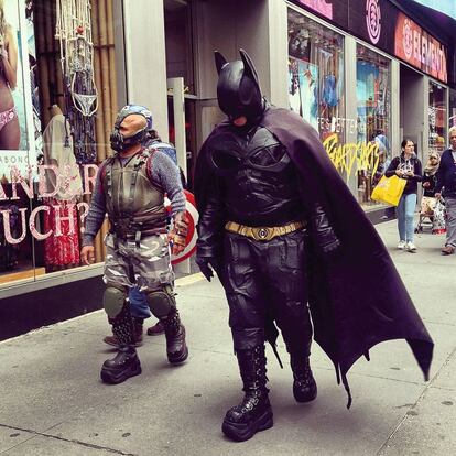 Hombres disfrazados del superhéroe Batman y su enemigo Bane.