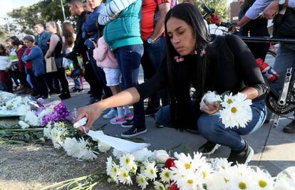 Una mujer coloca flores en un memorial a las afueras de la academia de policía en Bogotá.
