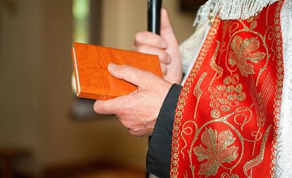 Un sacerdote porta una Biblia.