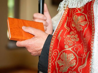 Un sacerdote porta una Biblia.