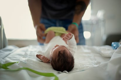 Un padre, identificado con una pulsera, cambia el pañal de su hija recién nacida en el hospital Sant Pau de Barcelona.