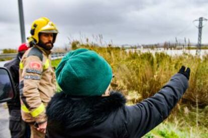 Una señora pide ayuda a los bomberos porque sus perros están atrapados en la zona inundada.