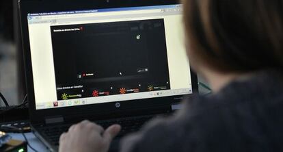 Una mujer consulta la página web de RTVA, en negro por el paro parcial.