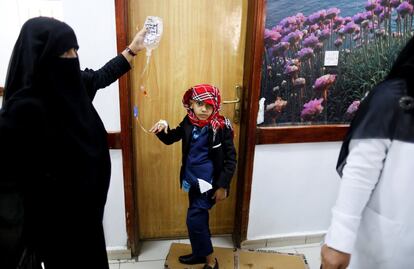 Una mujer sujeta la solución de quimioterapia IV para su hijo en el Centro Nacional de Oncología de Sanaa (Yemen).