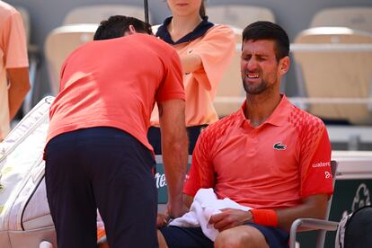 Djokovic es atendido por el fisioterapeuta tras sentir molestias en su brazo derecho.
