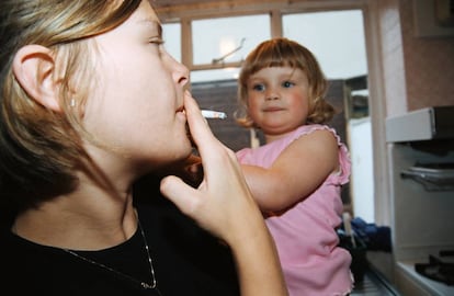 Una madre fuma enfrente de su hija.