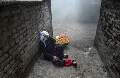 Una mujer se cubre la cara mientras la policía turca usa gas lacrimógeno durante los enfrentamientos en Diyarbakir.