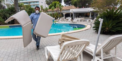 Un trabajador acondicionando la piscina en un hotel de Riu en Palma de Mallorca.