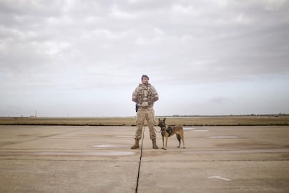 Un militar español de la base aérea controla la pista de aterrizaje junto a un perro de vigilancia y control.