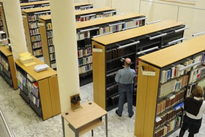 Dos personas consultan los fondos de la Biblioteca del Parlamento vasco.