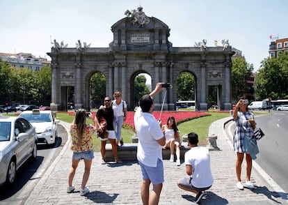 Unos turistas se fotografían ayer en la Puerta de Alcalá.