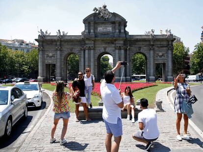 Unos turistas se fotografían ayer en la Puerta de Alcalá.