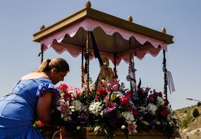 Irene Calderas, de la Peña Rociera de la Cañada Real, acomoda las flores que rodean la imagen antes de la suelta de la blanca paloma, un símbolo de la virgen.
